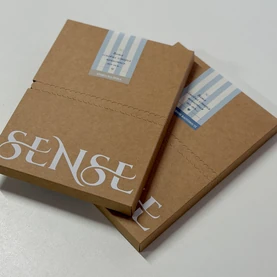 Дві запаковані посилки SENSE у крафтових коробках із фірмовими наліпками