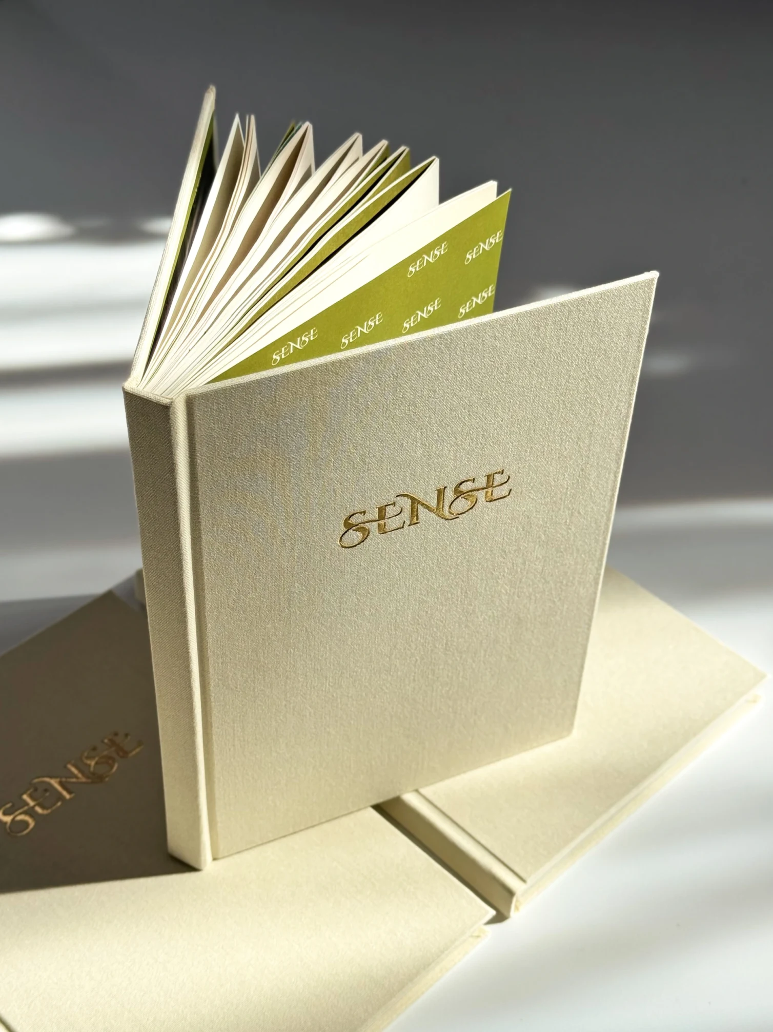 SENSE Baby Book in a cream cover with gold embossing