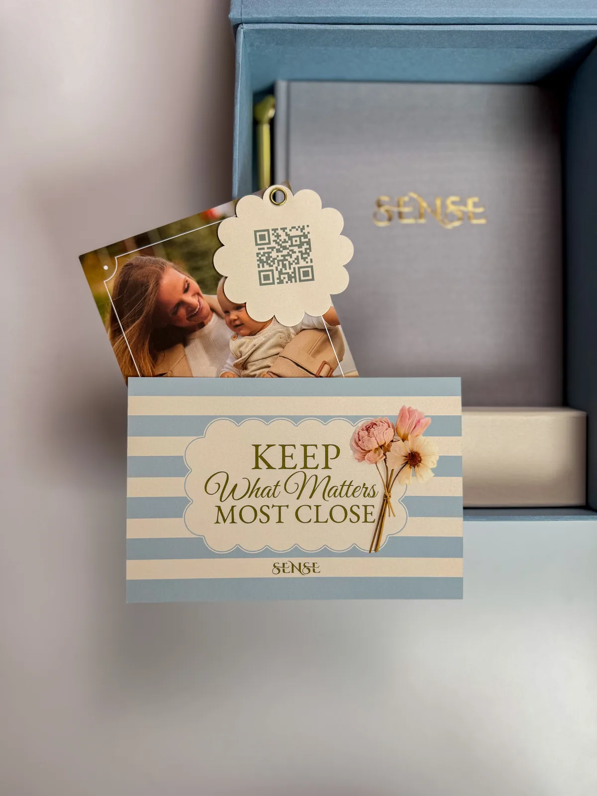 Light-blue SENSE pregnancy keepsake box with the English-edition journal and a card