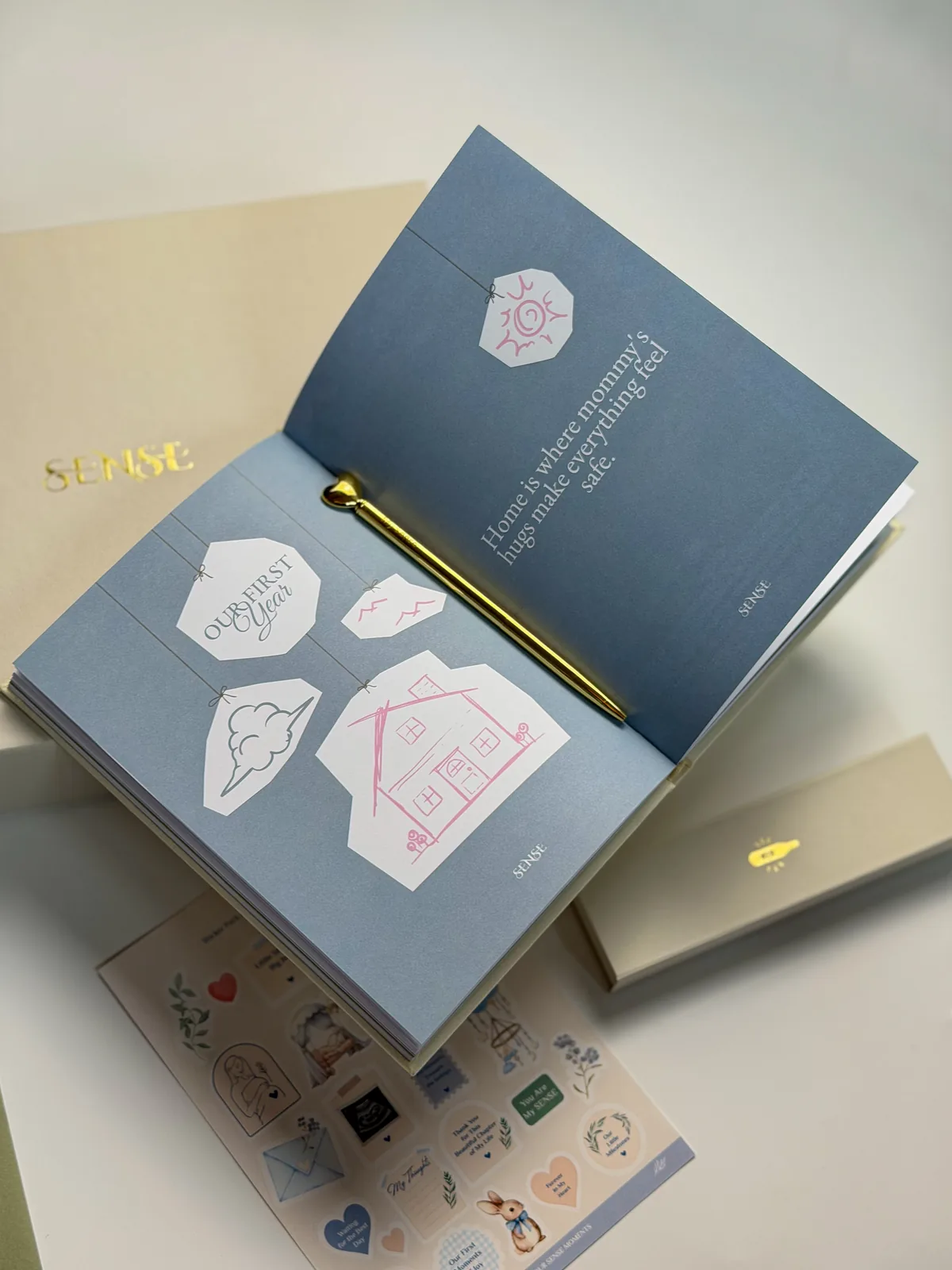 Open English-edition baby memory book with a sheet of stickers