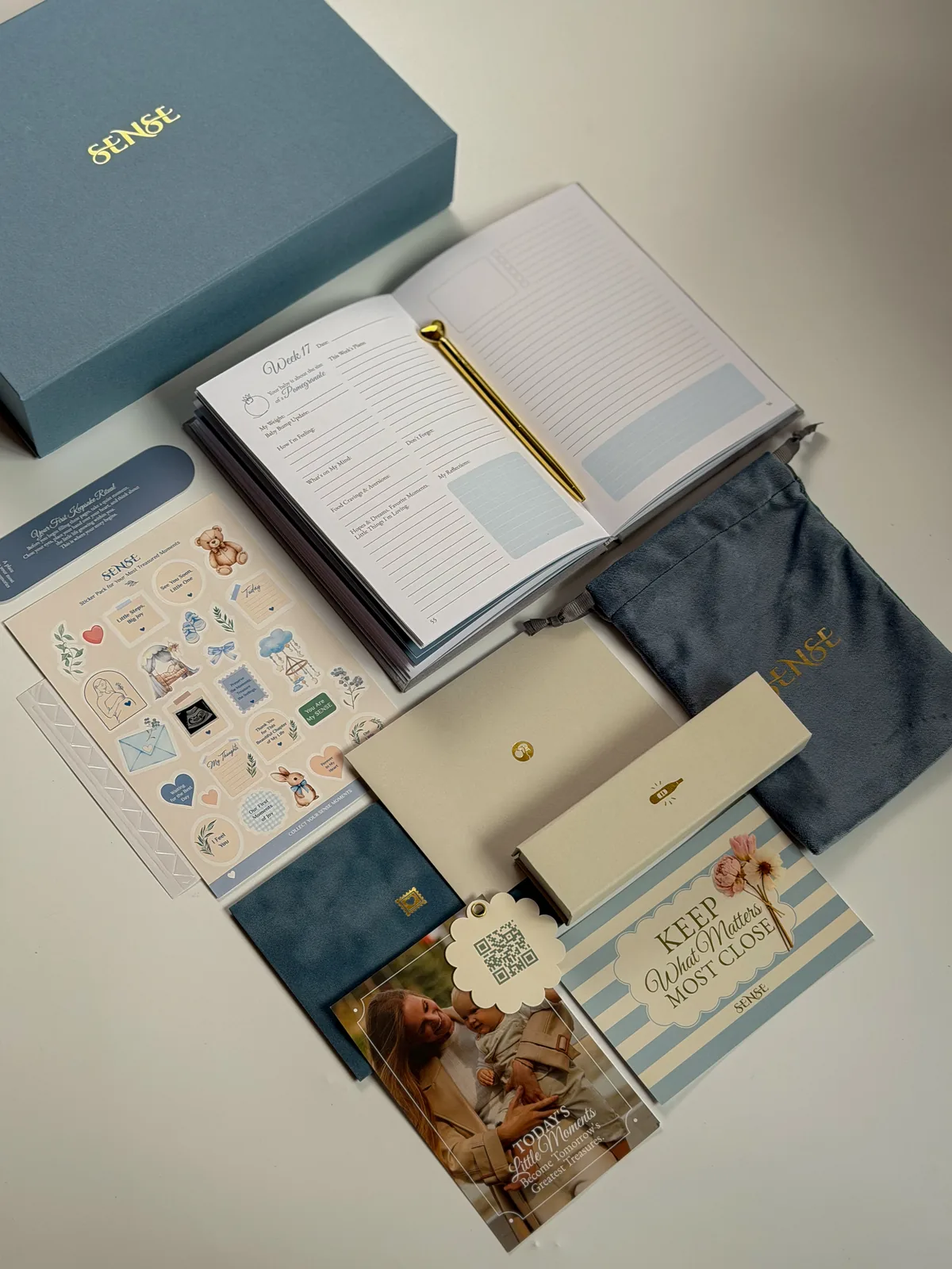Open English-edition pregnancy journal with stickers beside the light-blue box